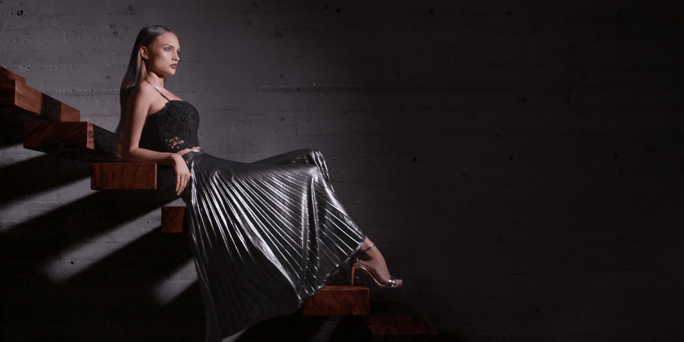 Elegant model seated on wooden staircase